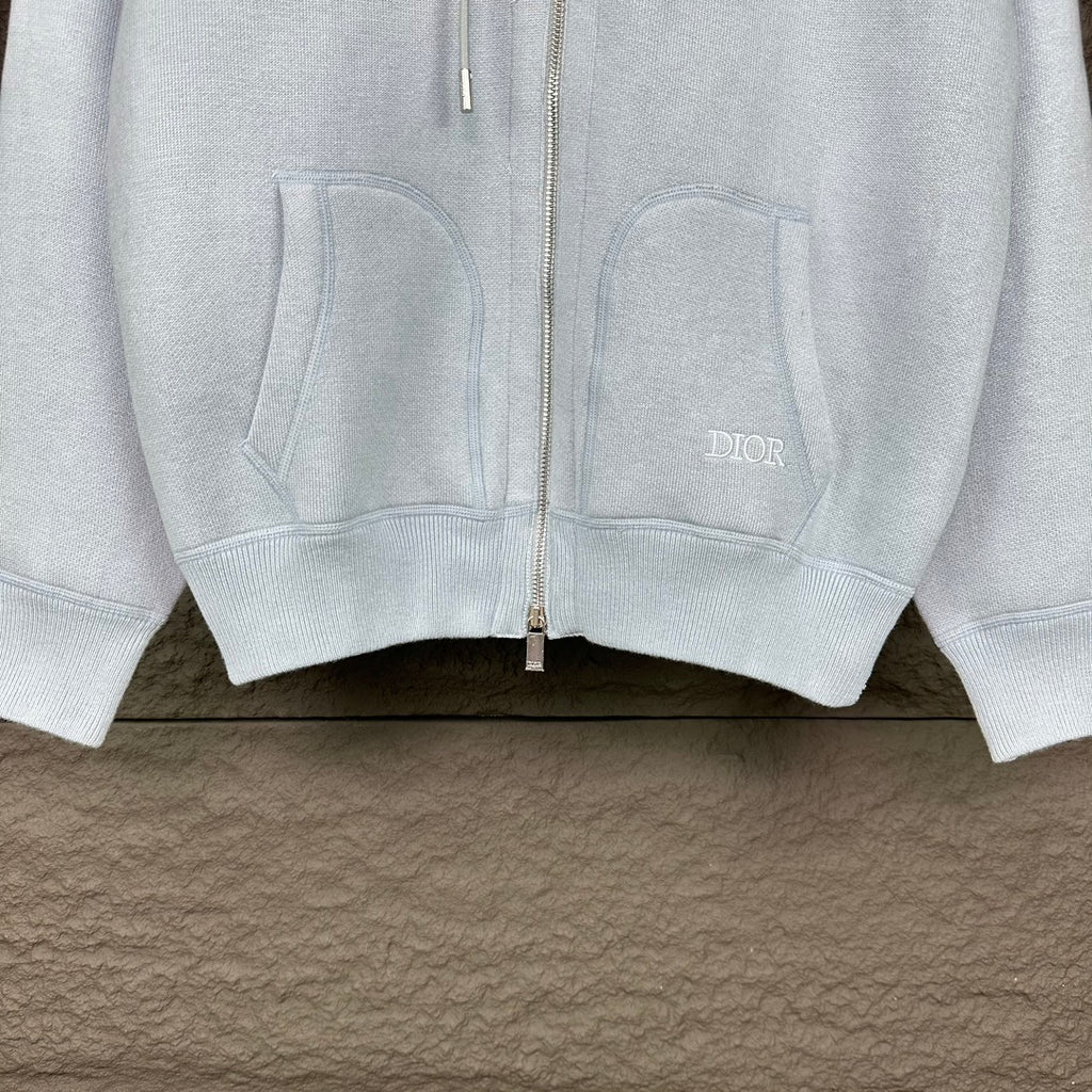 Light blue Dior zip-up hoodie front with pockets and logo patch