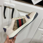 Gucci unisex sneakers, close side view, beige upper with logo panel and color stripe.