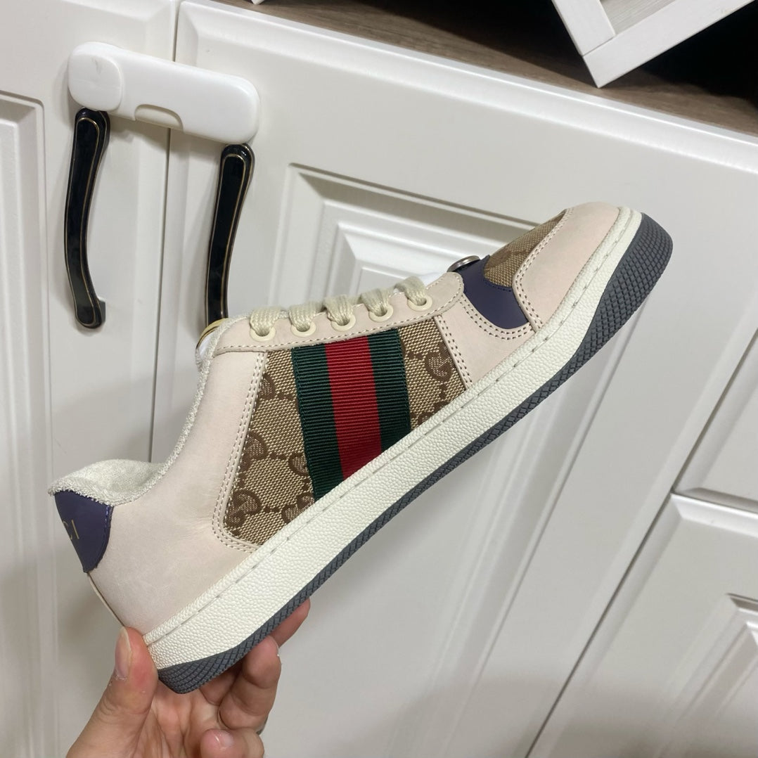 Gucci unisex sneakers, close side view, beige upper with logo panel and color stripe.