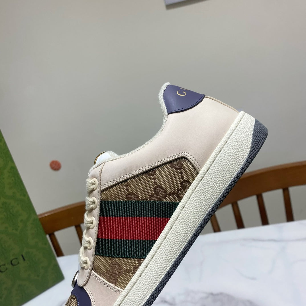 Gucci unisex sneakers, quarter view, beige upper with logo panel and dark blue collar.