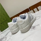 White Gucci unisex sneakers with “GUCCI” heel tabs and gray side stripes