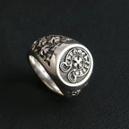 Chrome signet ring with oval emblem and carved floral pattern on band
