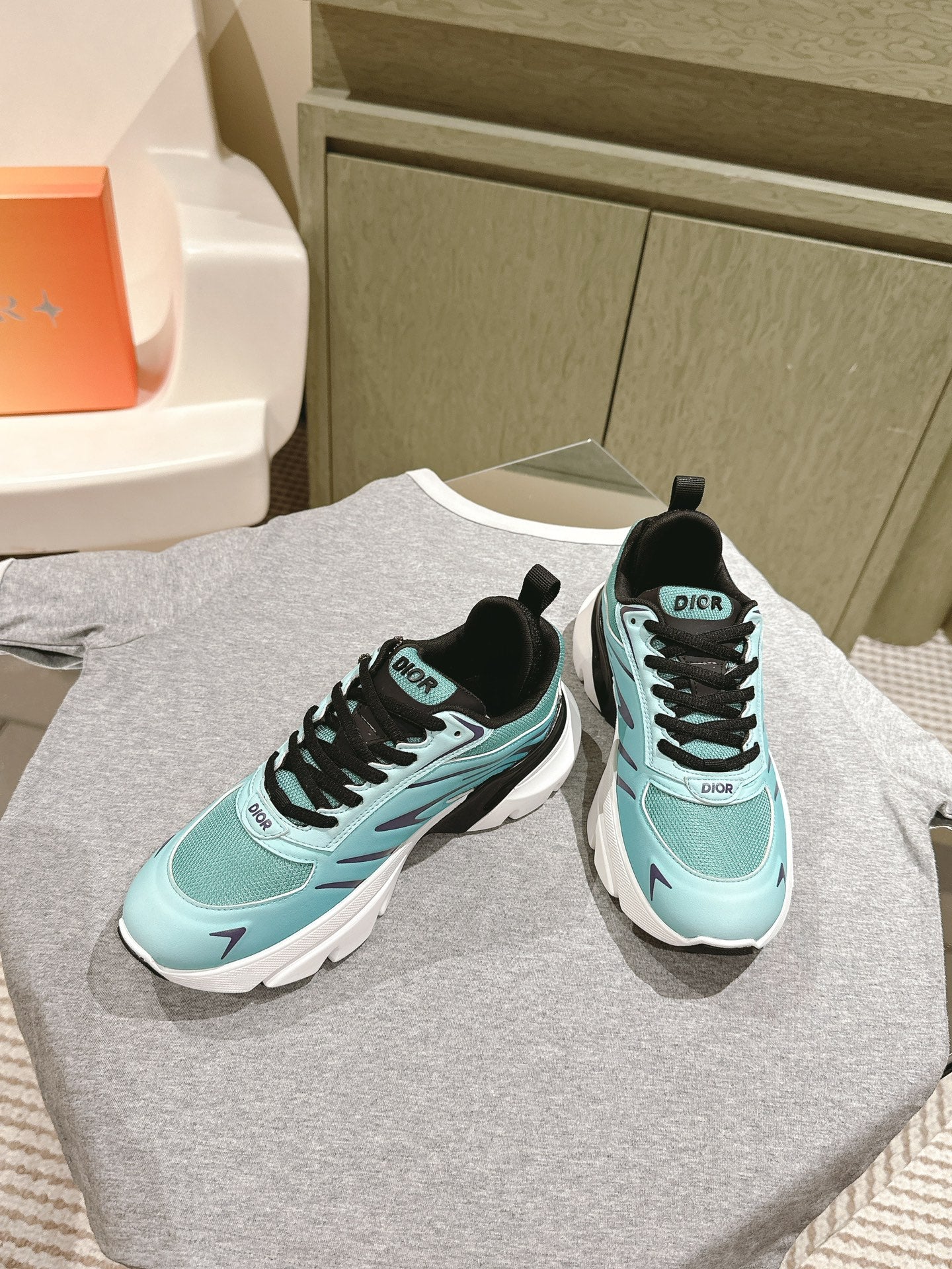 Mint and black lace-up sneakers with white midsoles and Dior branding on uppers