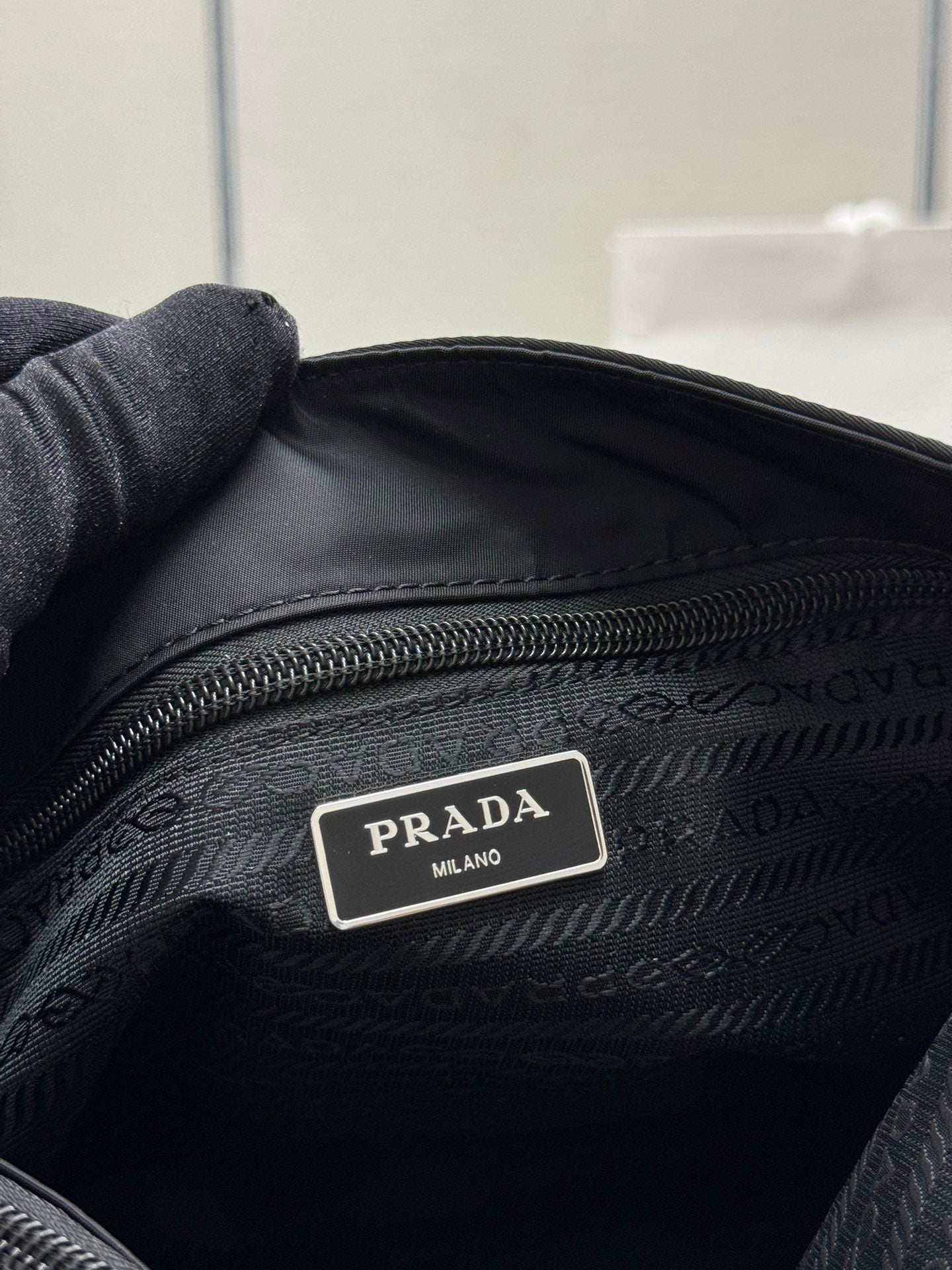 Black tote bag close-up of interior logo label