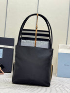 Black tote bag with top handles and front logo plaque