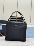 Black Prada tote bag with dual top handles and front triangular logo plate.