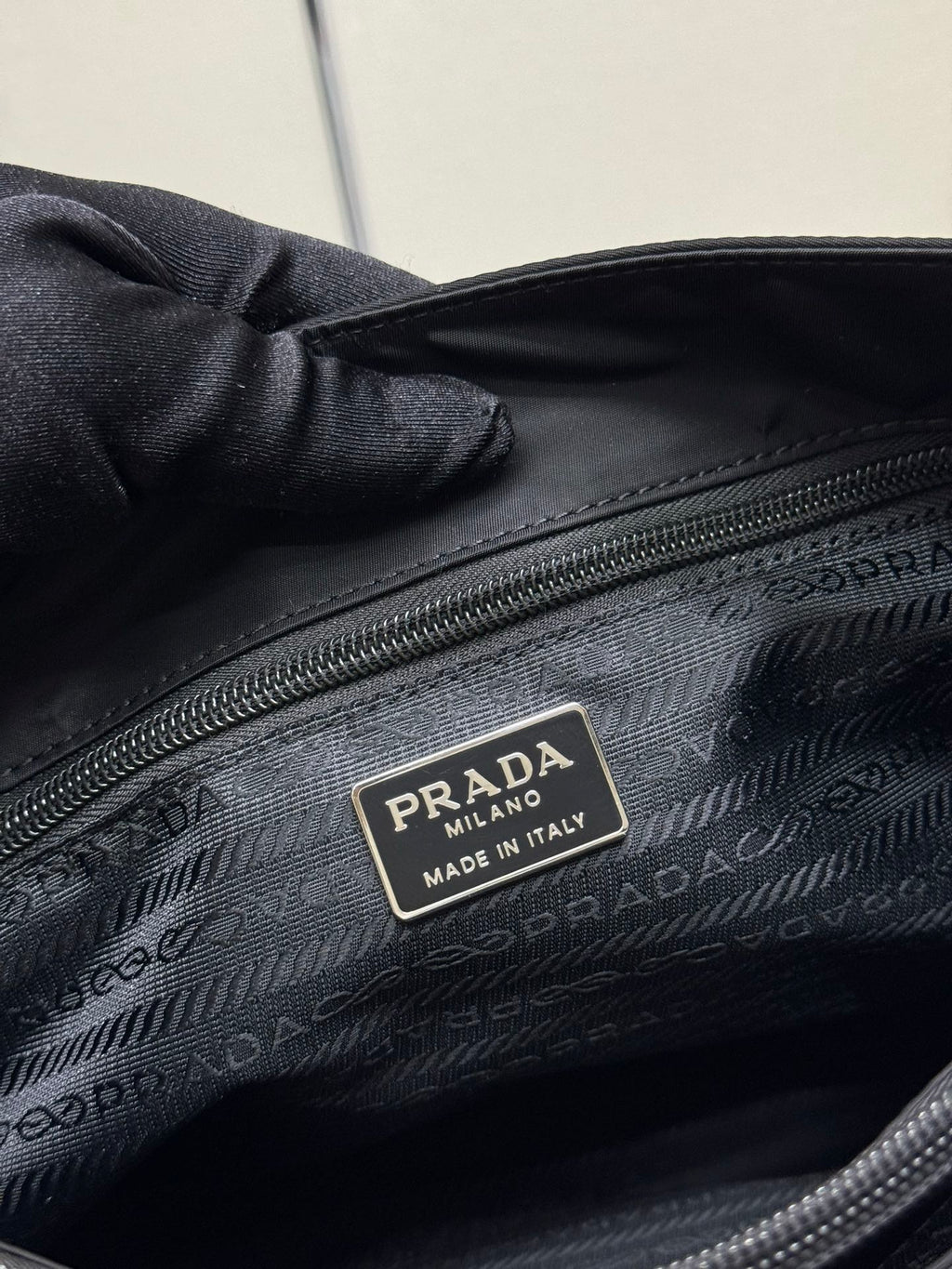 Black Prada tote bag interior close-up with PRADA Made in Italy label.