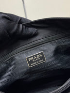 Black Prada tote bag interior close-up with PRADA Made in Italy label.