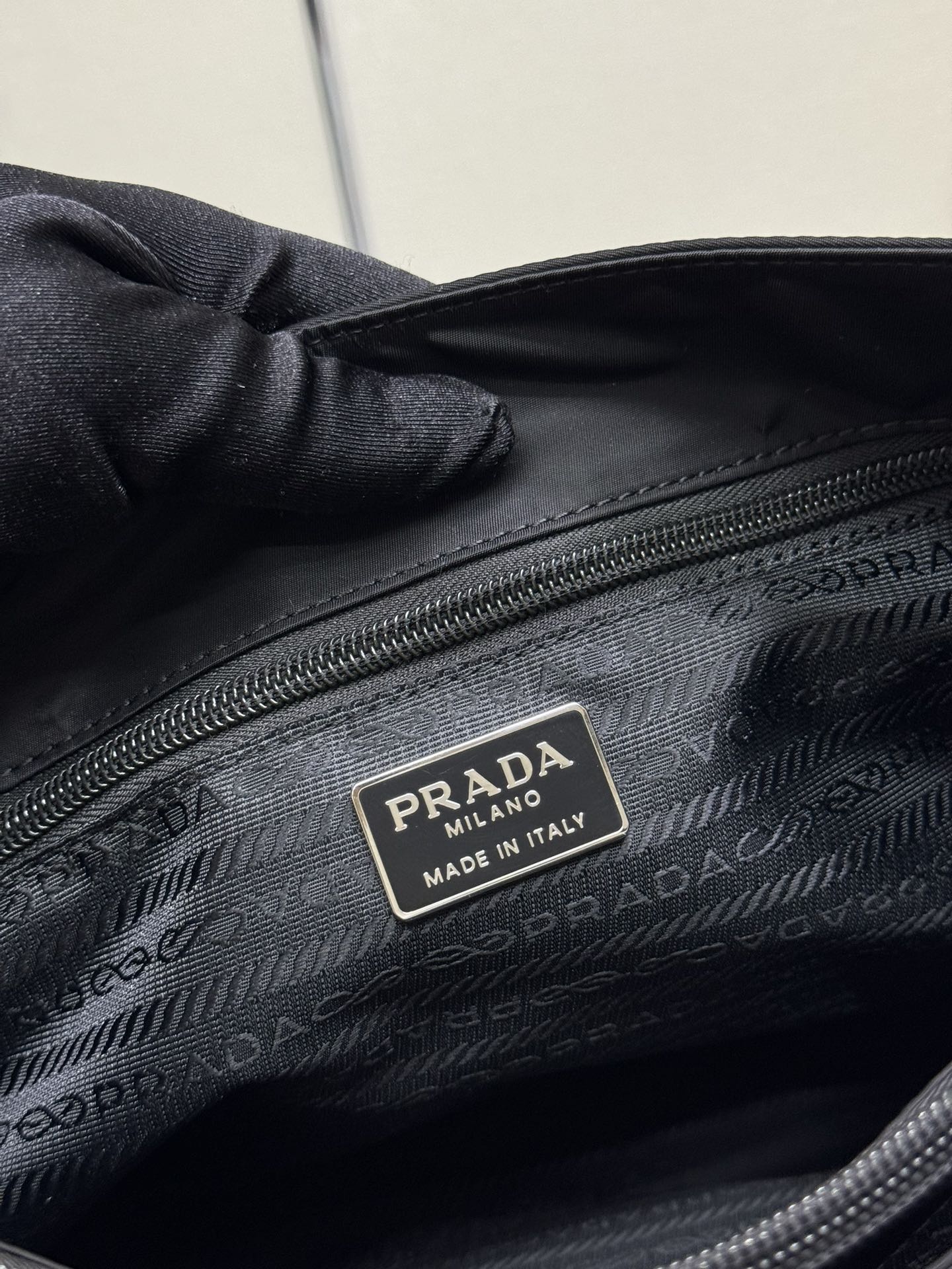 Black Prada tote bag interior close-up with PRADA Made in Italy label.