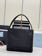 Black Prada tote bag with top handles and front logo band detail.