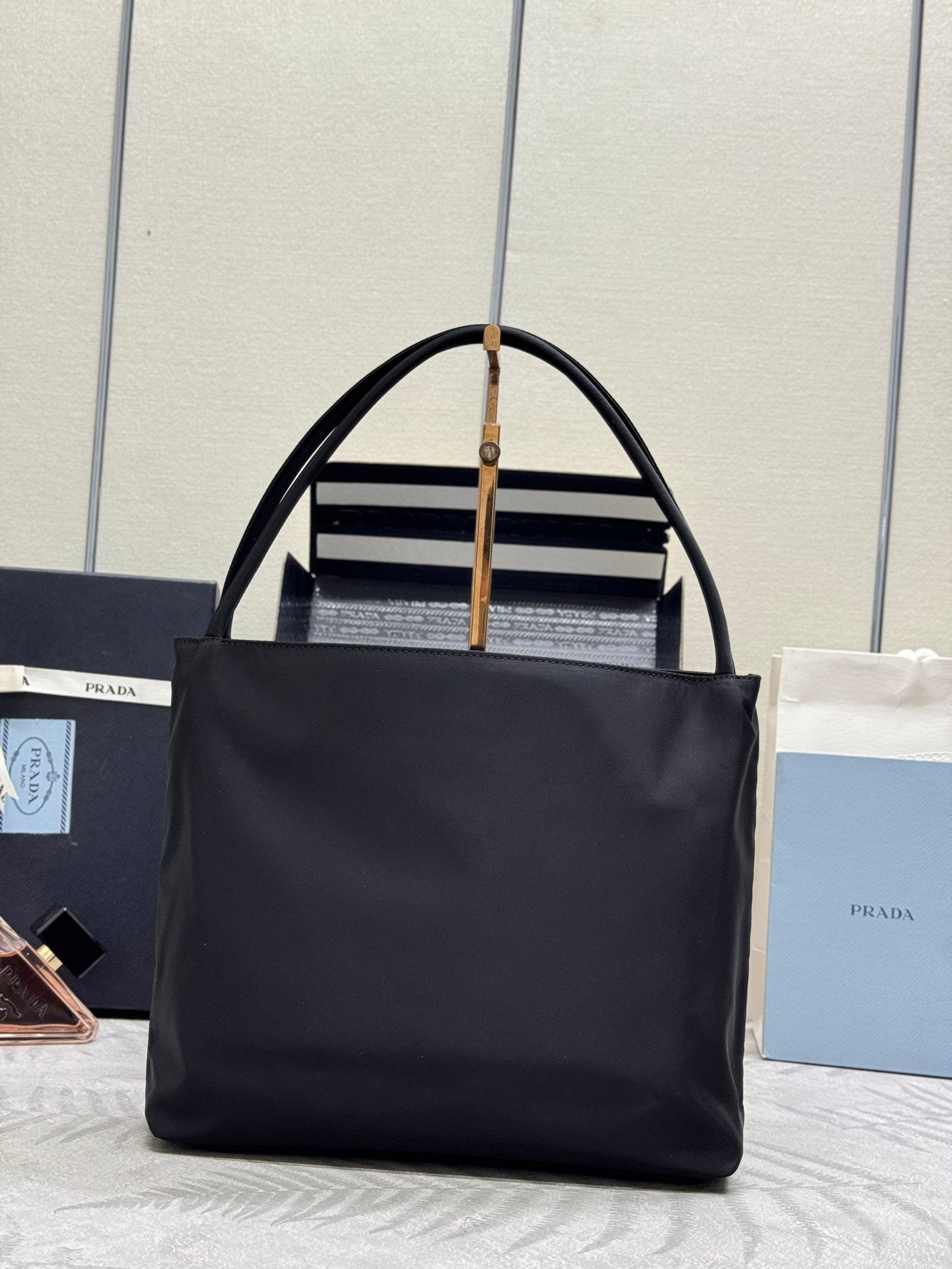Black Prada tote bag with top handles and front logo band detail.