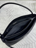 Black Prada tote bag interior close-up showing twin zip compartments and hardware.