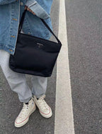 Prada black nylon tote bag with top handles and triangular logo plaque