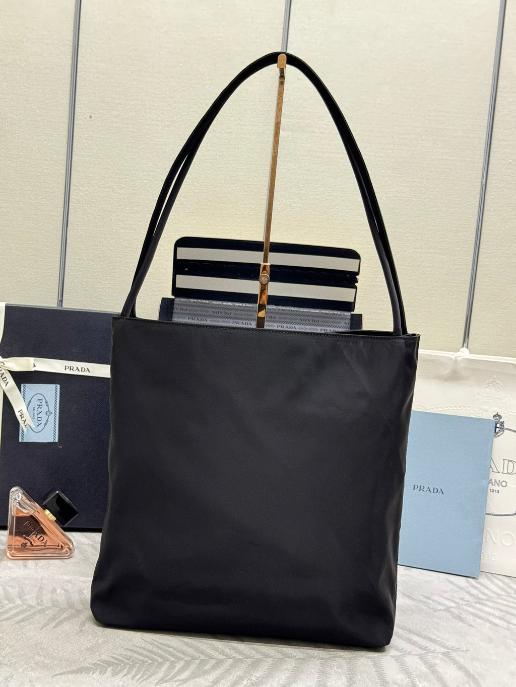 Prada tote bag in dark nylon with top handles and front logo badge with striped trim