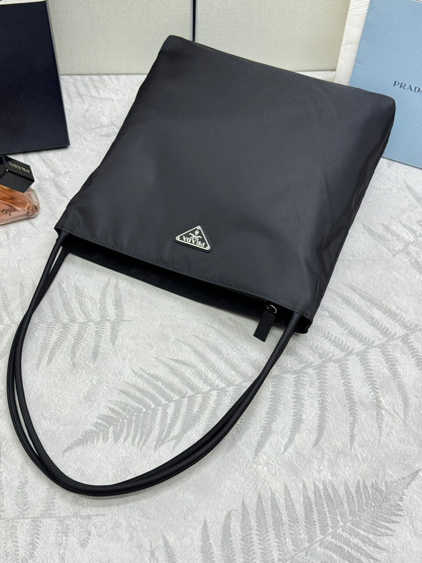 Prada shoulder bag in dark nylon with fold-over flap, triangular logo, and long strap