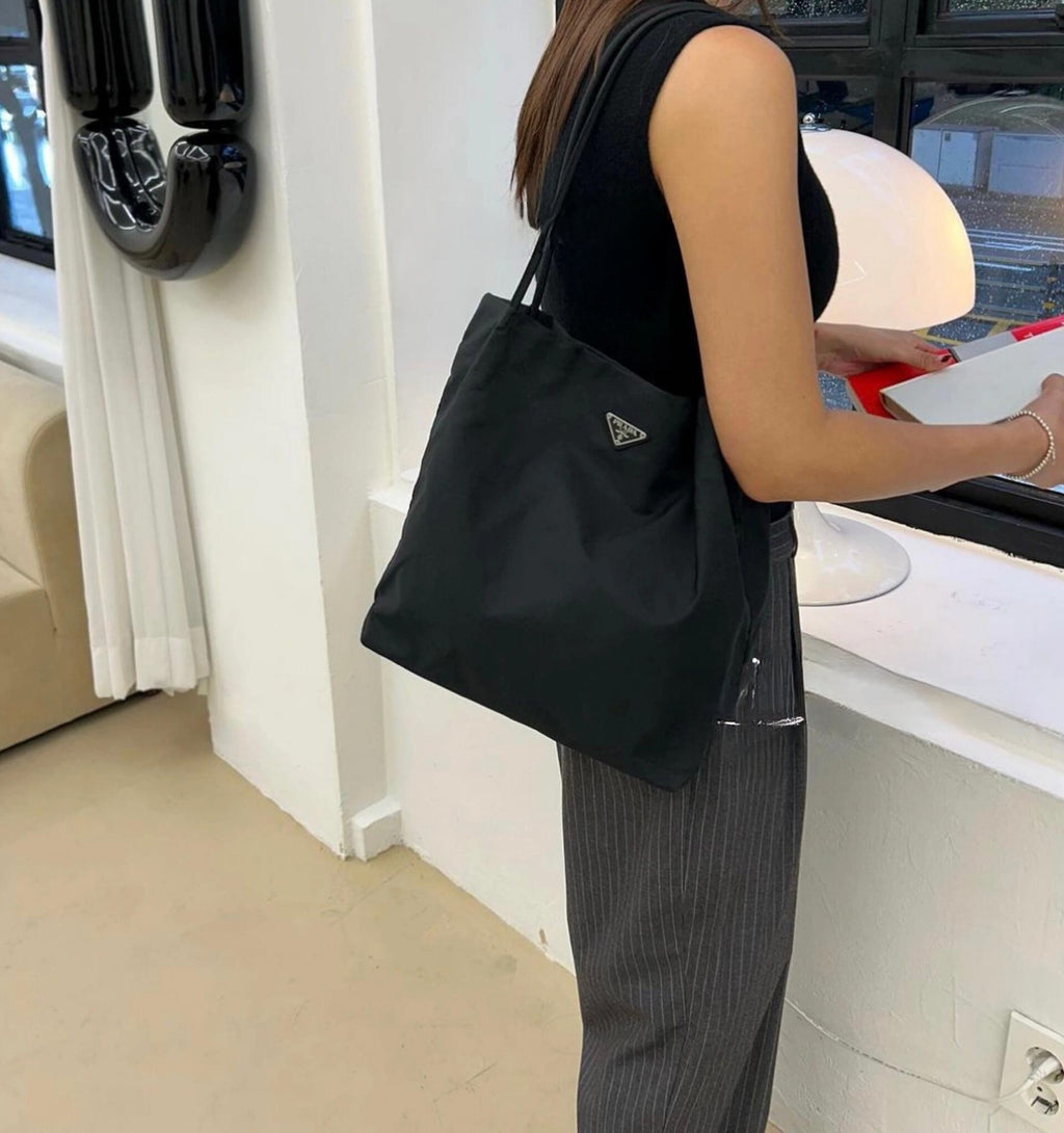 Prada nylon tote bag in black, triangular Prada logo, side view