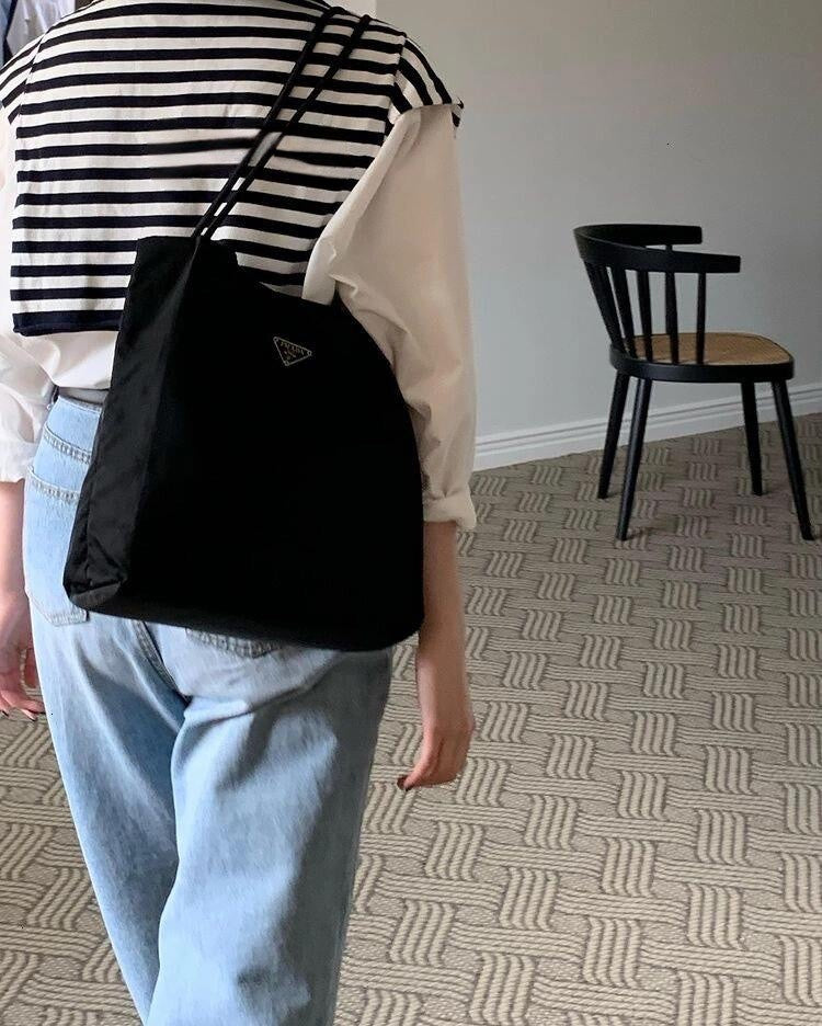 Prada nylon tote bag in black, triangular logo patch and top handles