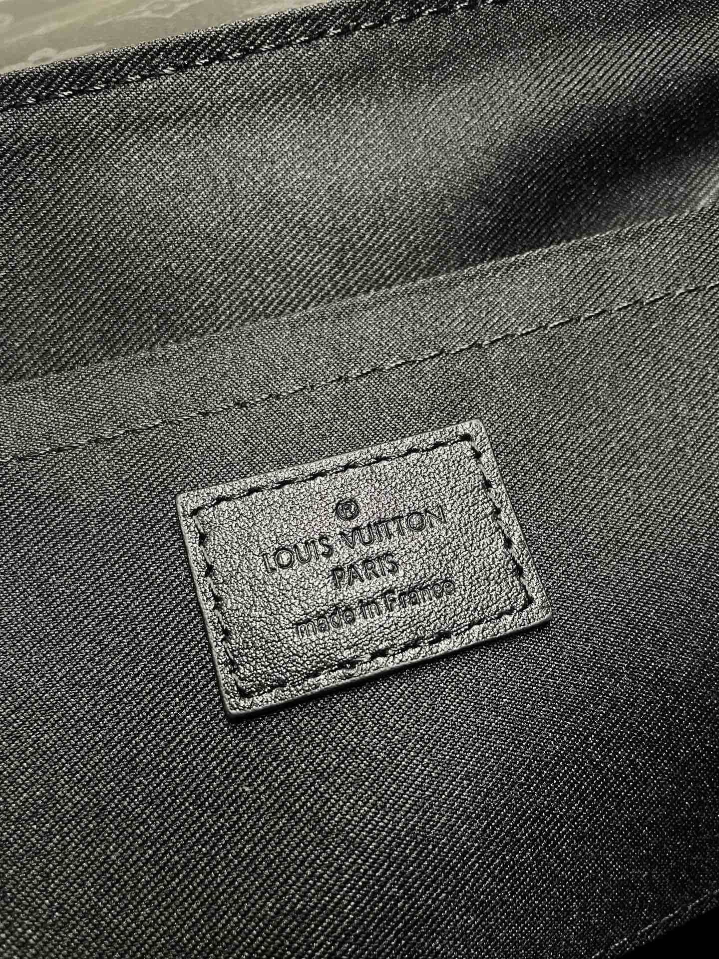 Louis Vuitton interior label patch on dark fabric, stitched logo badge close-up