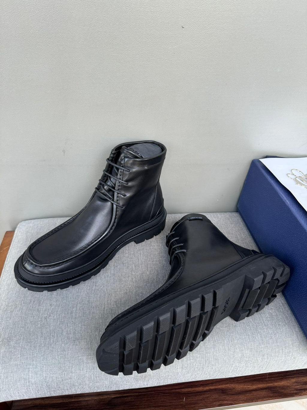 Black leather lace-up boots with rugged tread sole, heel and outsole visible