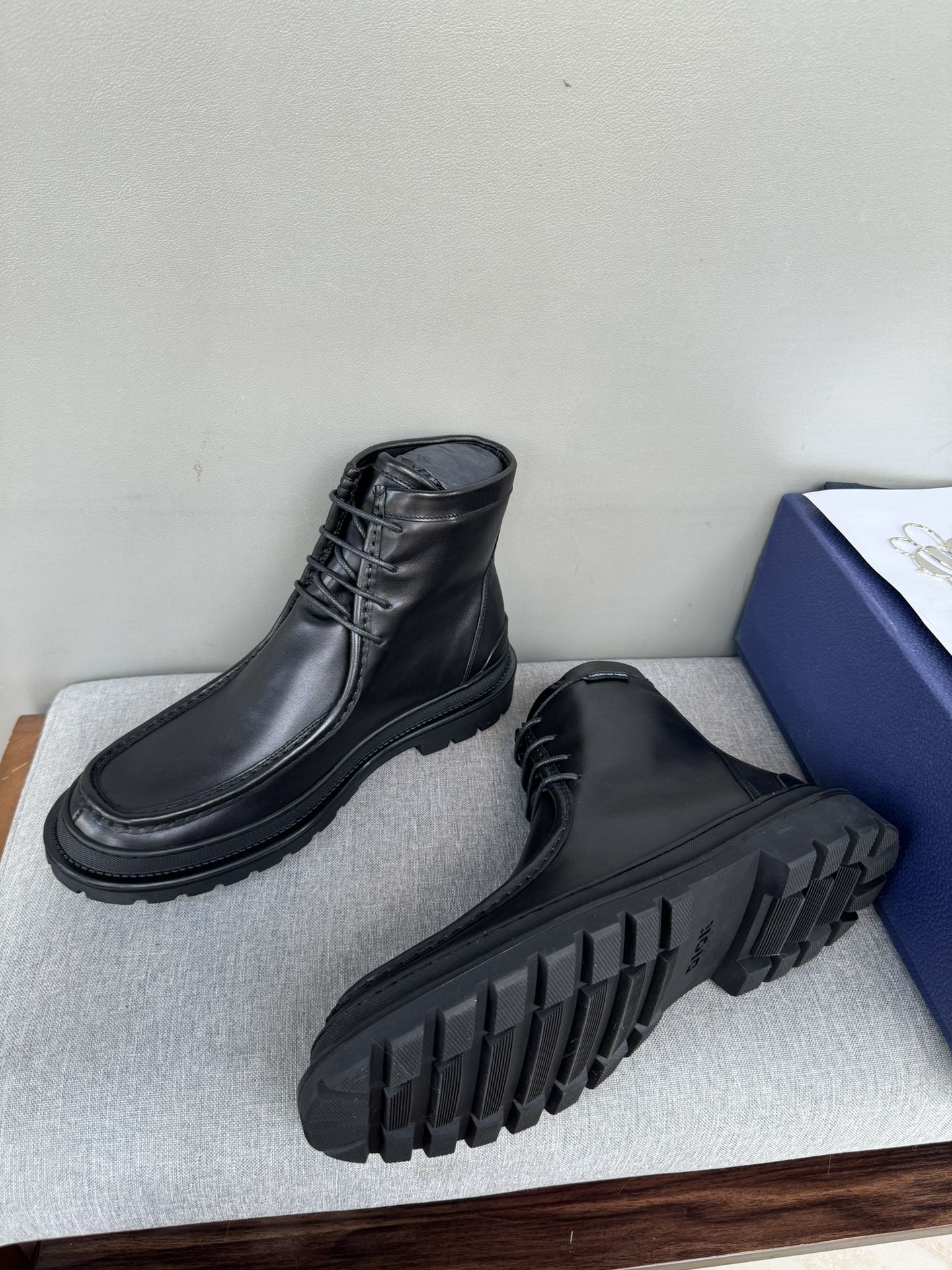 Black leather lace-up boots with rugged tread sole, heel and outsole visible