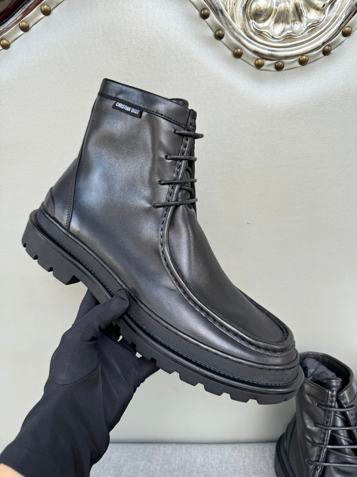 Black leather lace-up boot, lace detail and sidewall sole visible