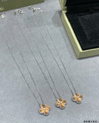 Set of silver-tone flower pendant necklaces on velvet display