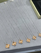 Multiple silver-tone flower pendant necklaces with gold-tone flower detail