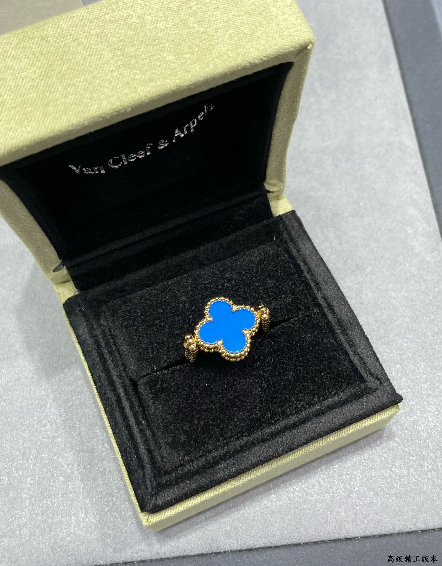 Blue enamel clover-shaped ring in a gold-edged gift box