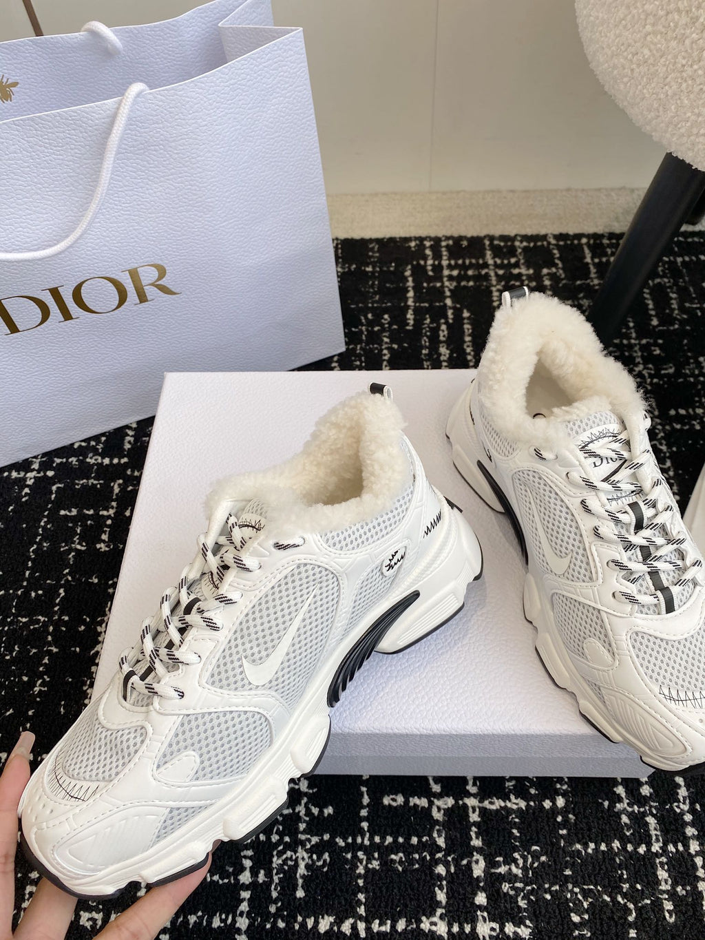 Dior unisex white sneakers with lace-up front and wool-like shearling around collar.