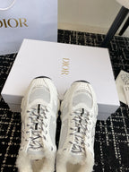 Dior unisex white sneakers with lace-up eyelets and mesh toe panels.