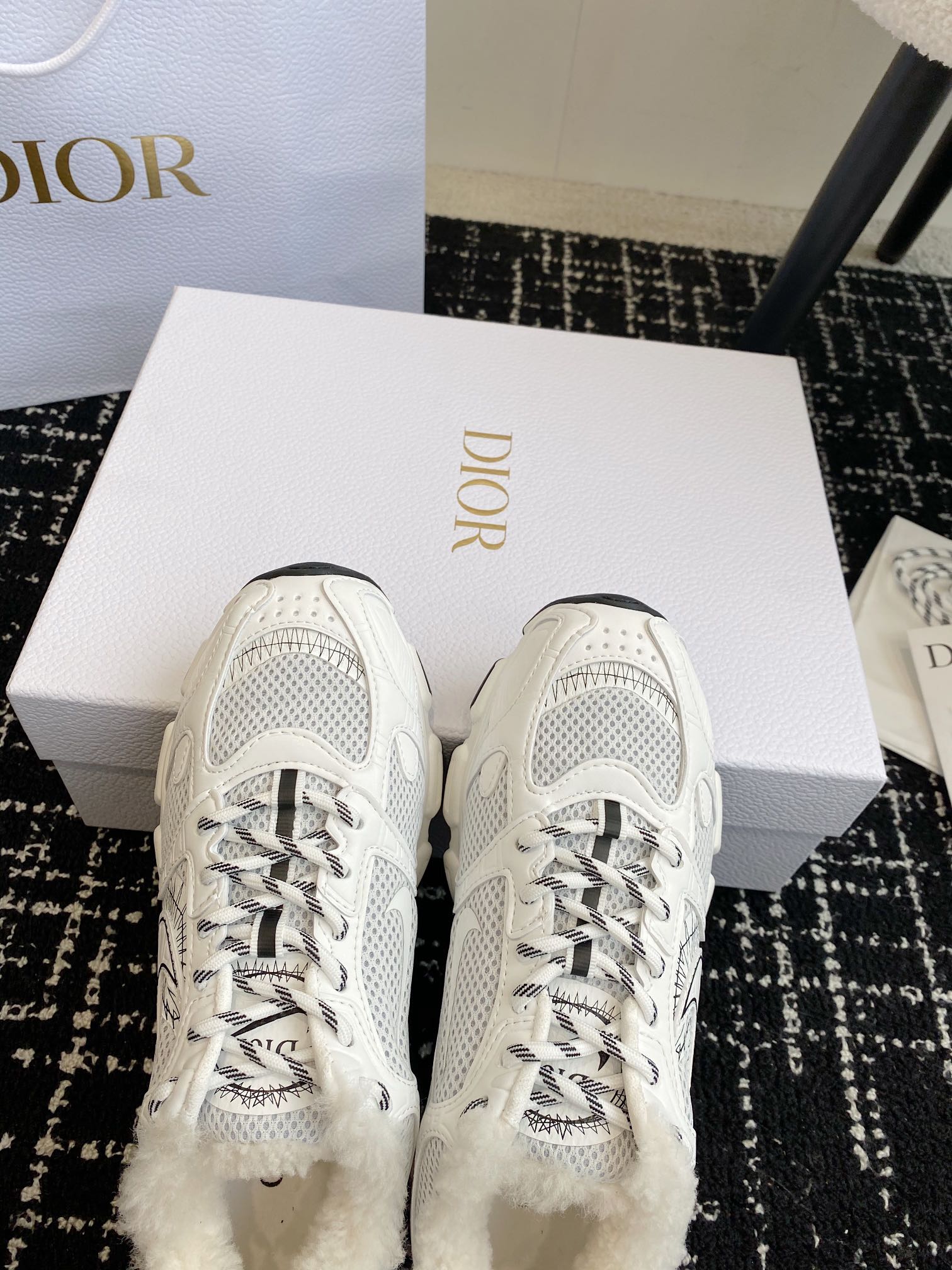 Dior unisex white sneakers with lace-up eyelets and mesh toe panels.