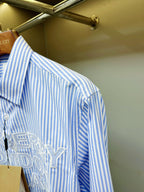 Light blue striped Burberry button-up shirt sleeve and front logo detail