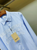 Light blue striped Burberry button-up shirt, front logo print close-up