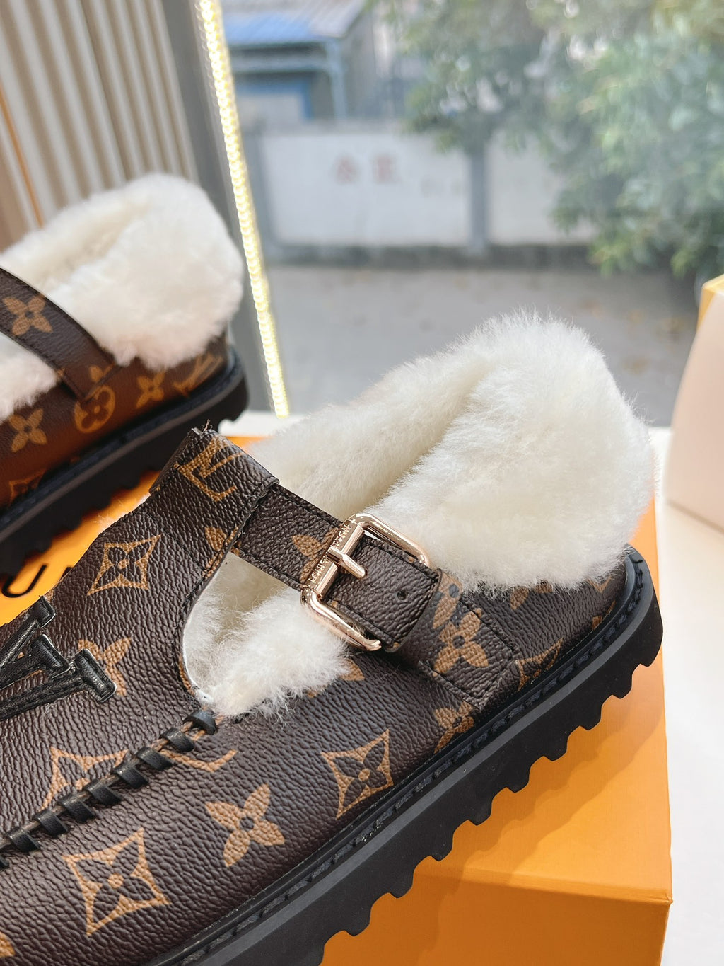 Louis Vuitton monogram loafer close-up with wide strap buckle and white shearling
