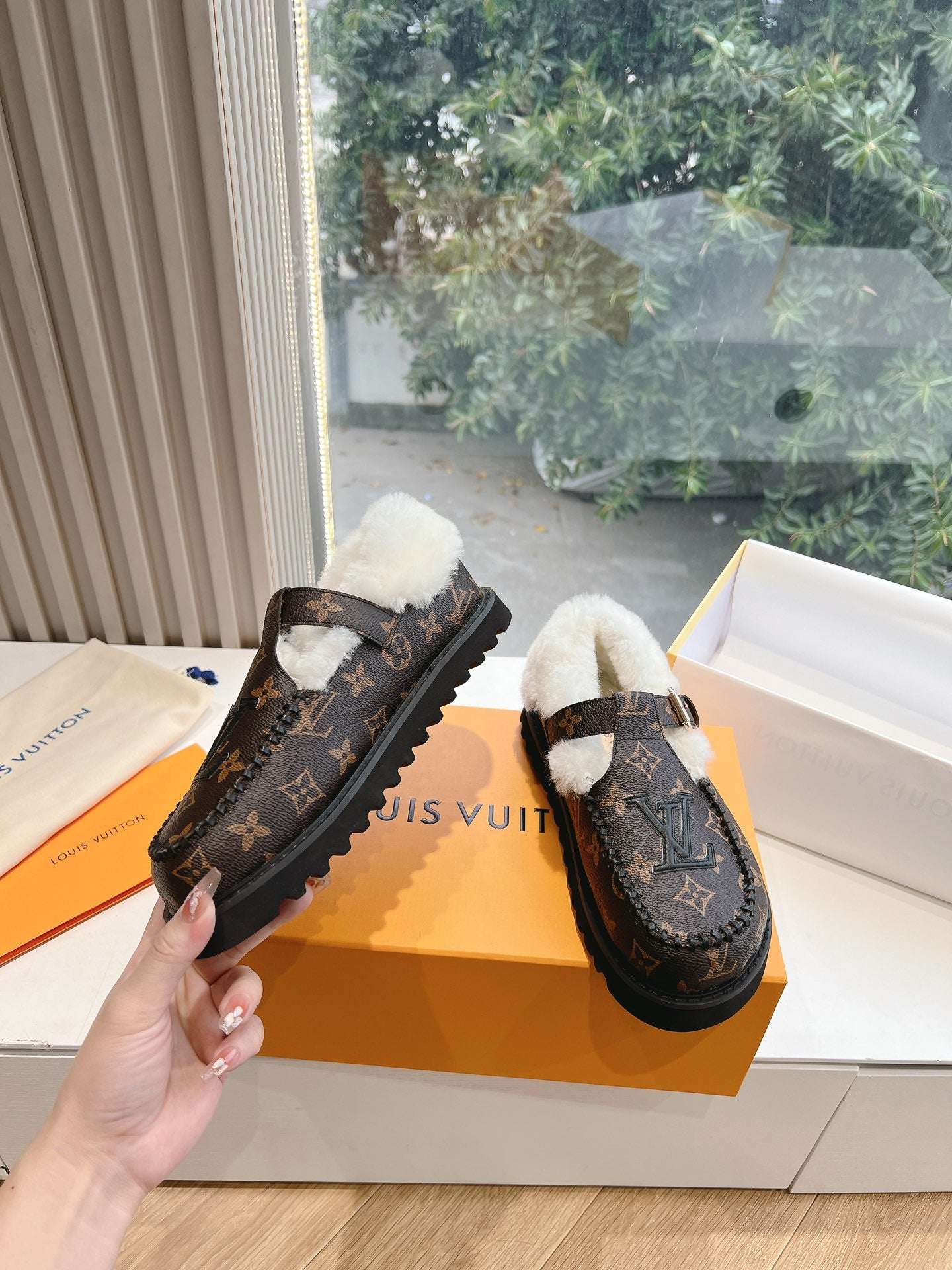 Louis Vuitton monogram loafers with white shearling lining, shown side by side
