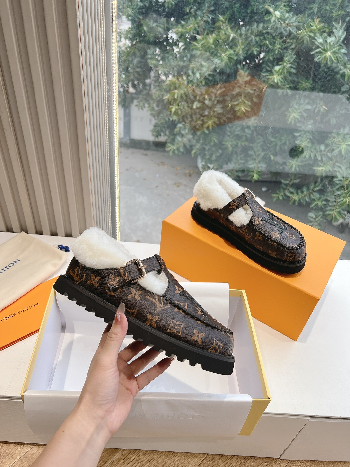 Louis Vuitton monogram loafer with white shearling lining and buckle strap