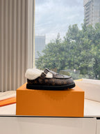 Louis Vuitton monogram loafer with white shearling lining and strap buckle, side view