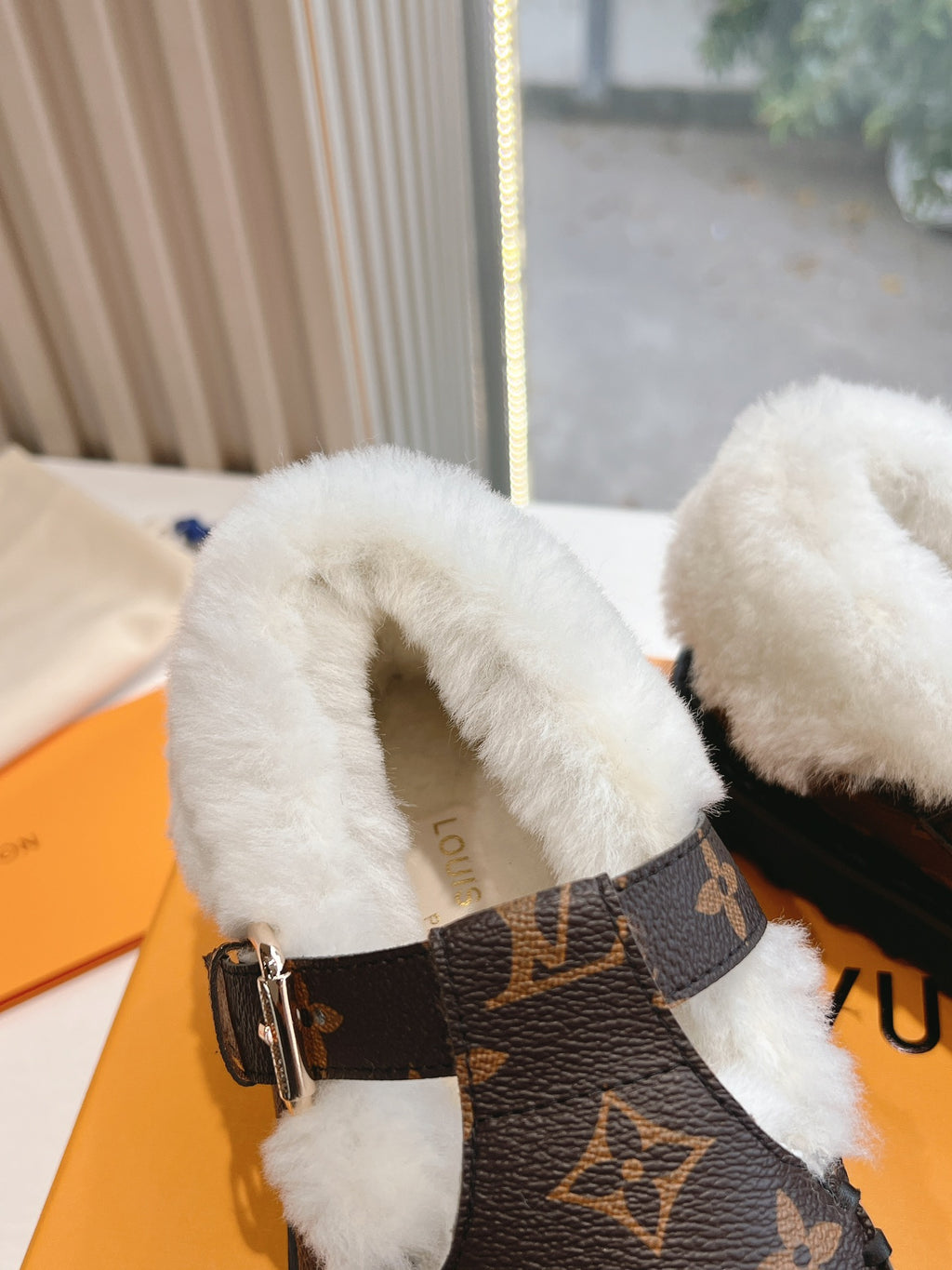 Louis Vuitton monogram loafer close-up with white shearling lining and metal buckle