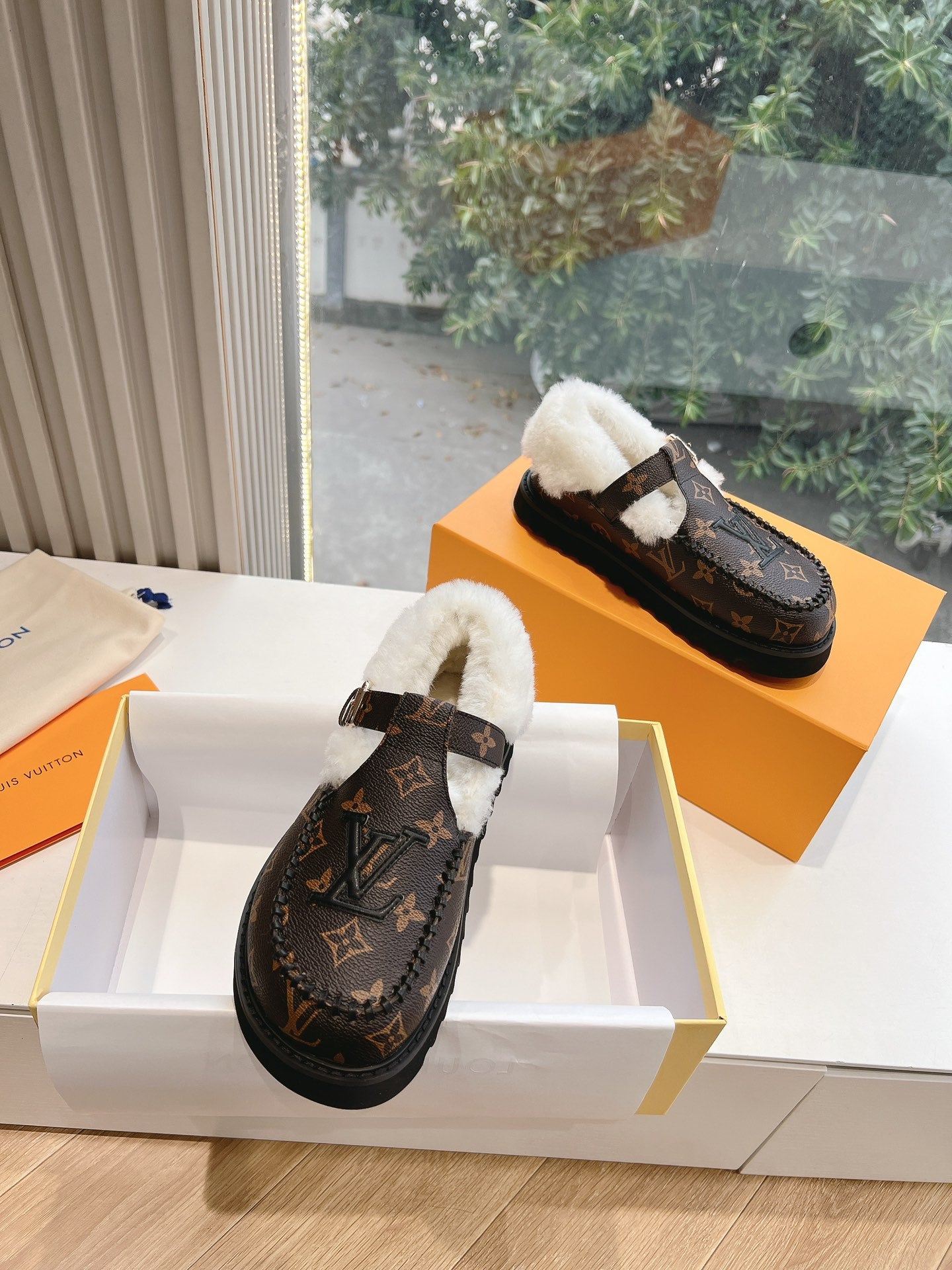 Louis Vuitton monogram slippers with white shearling lining and side buckle detail
