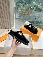 Black suede Louis Vuitton loafers with shearling trim and LV logo detail