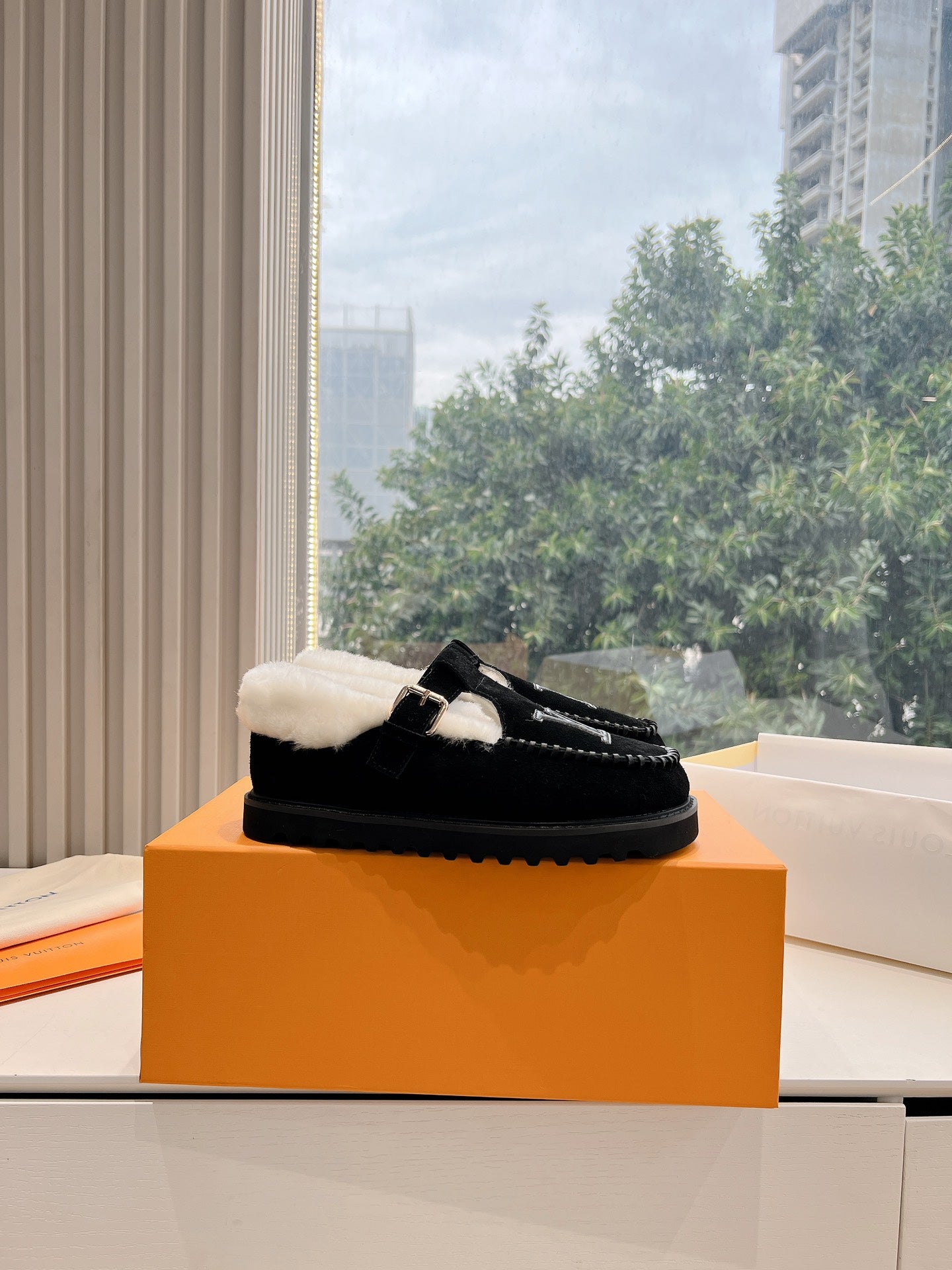 Black Louis Vuitton moccasin loafers with cream shearling lining and chunky sole