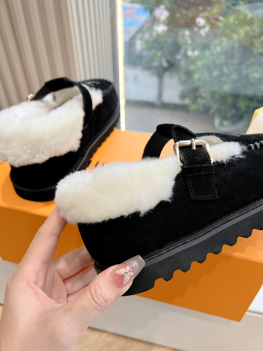 Black Louis Vuitton loafer with cream shearling lining, buckle strap, and chunky sole