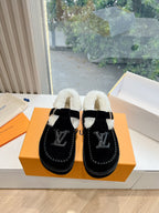 Pair of black Louis Vuitton unisex loafers with cream shearling lining and LV logo
