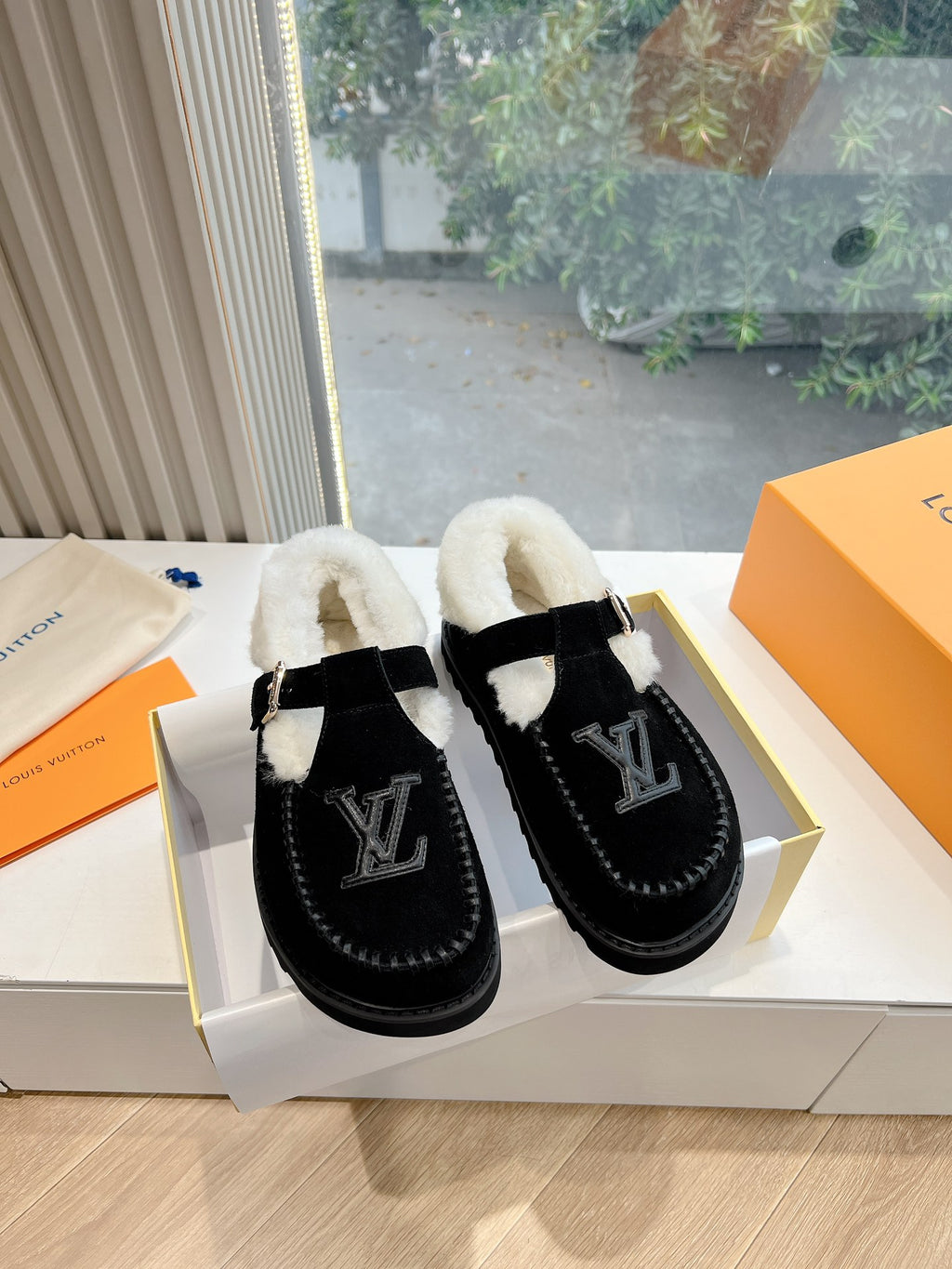 Black Louis Vuitton unisex loafers with faux shearling lining and LV logo on uppers