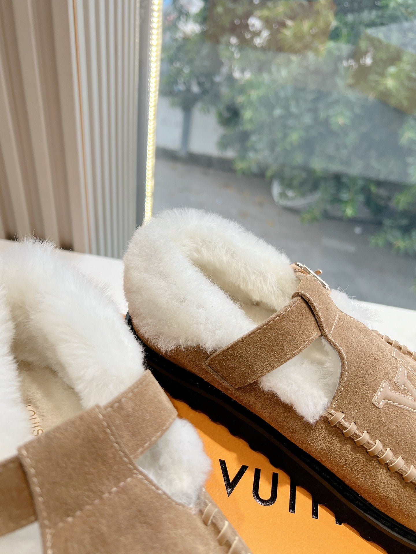 Louis Vuitton tan suede shearling mules with buckled strap and LV side logo