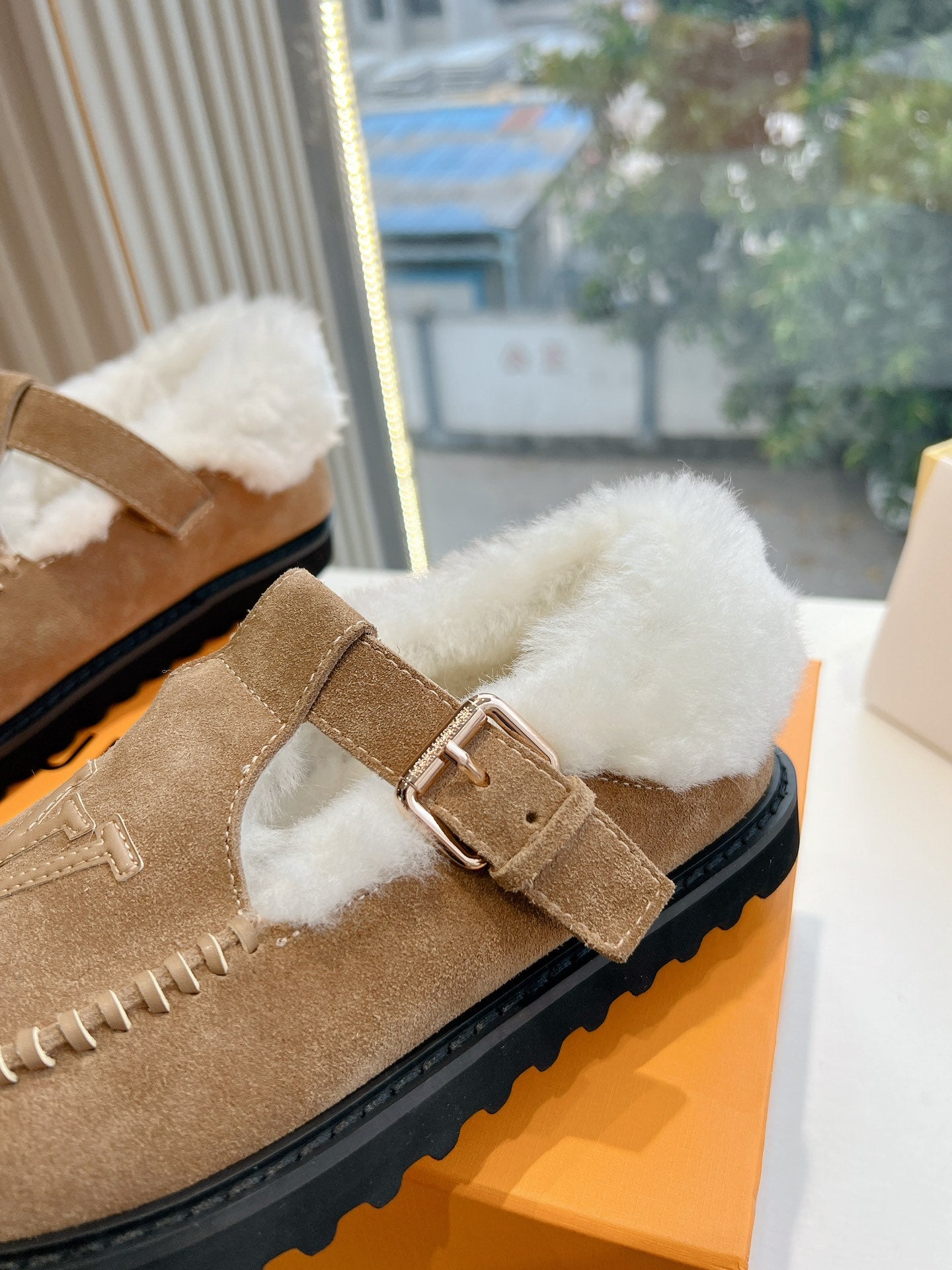 Louis Vuitton tan suede shearling mule with buckle strap and white fur lining