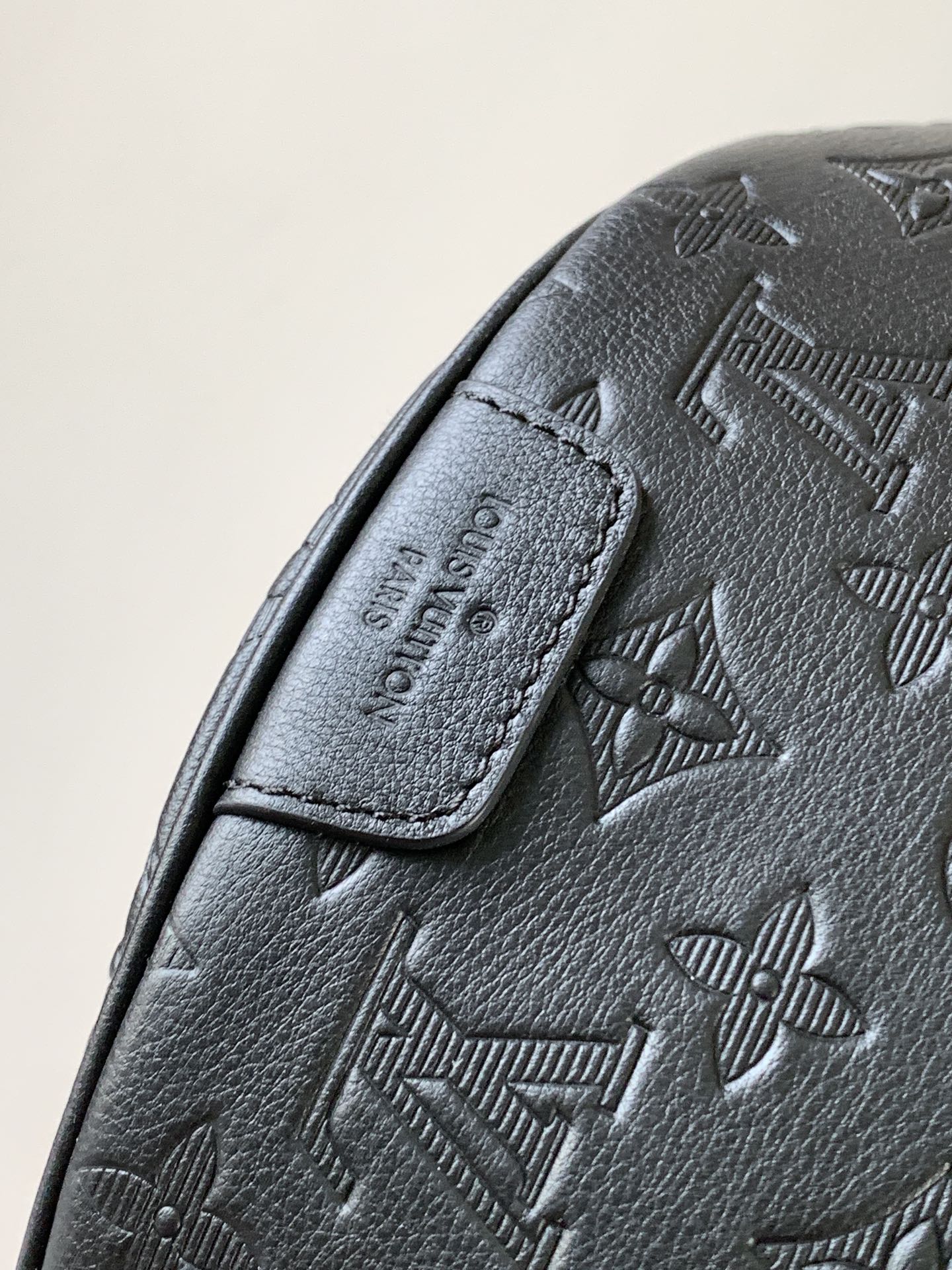 Louis Vuitton monogram crossbody bag close-up of stitched leather strap tab