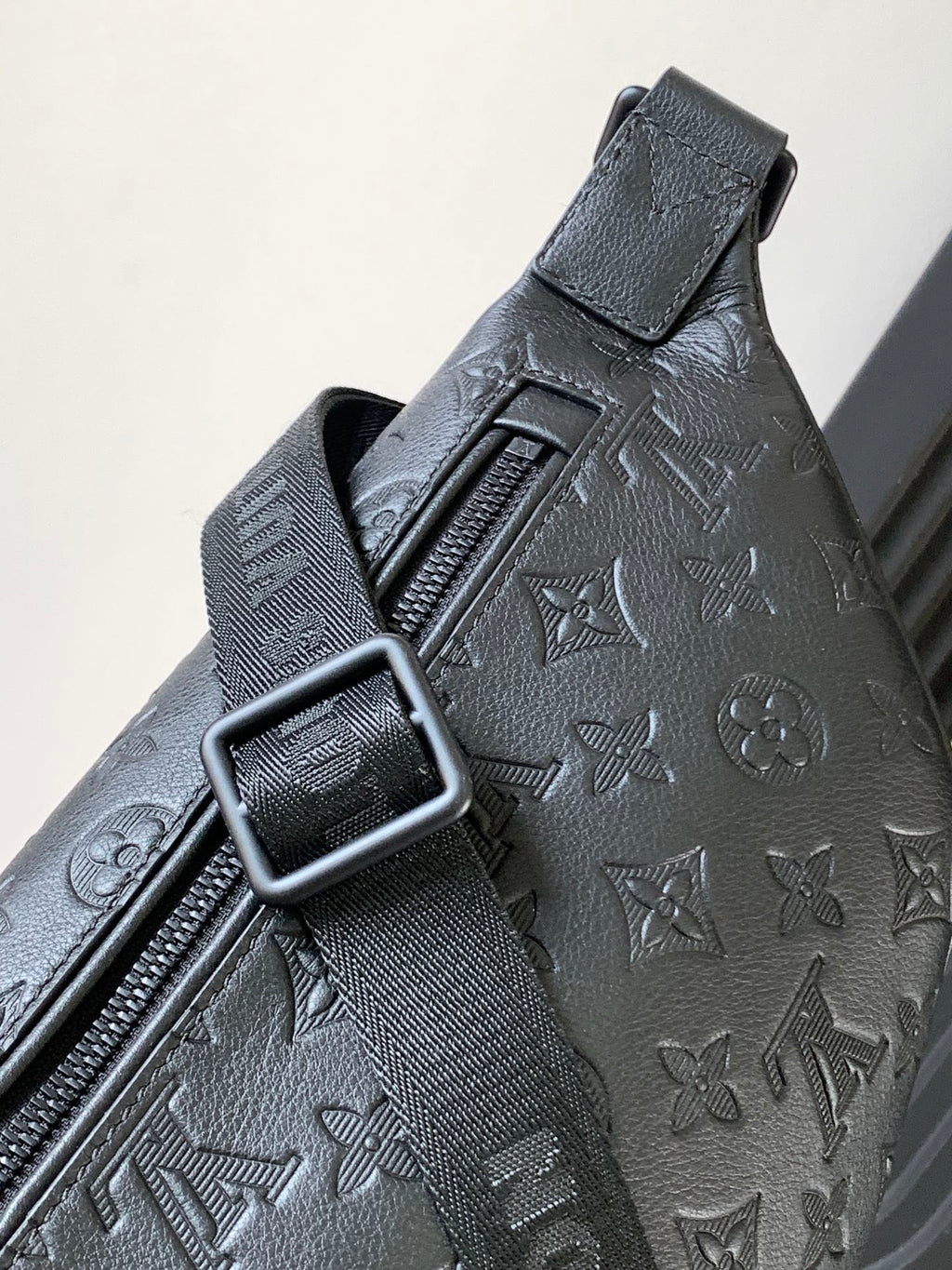 Louis Vuitton monogram crossbody bag close-up of strap buckle and embossed pattern