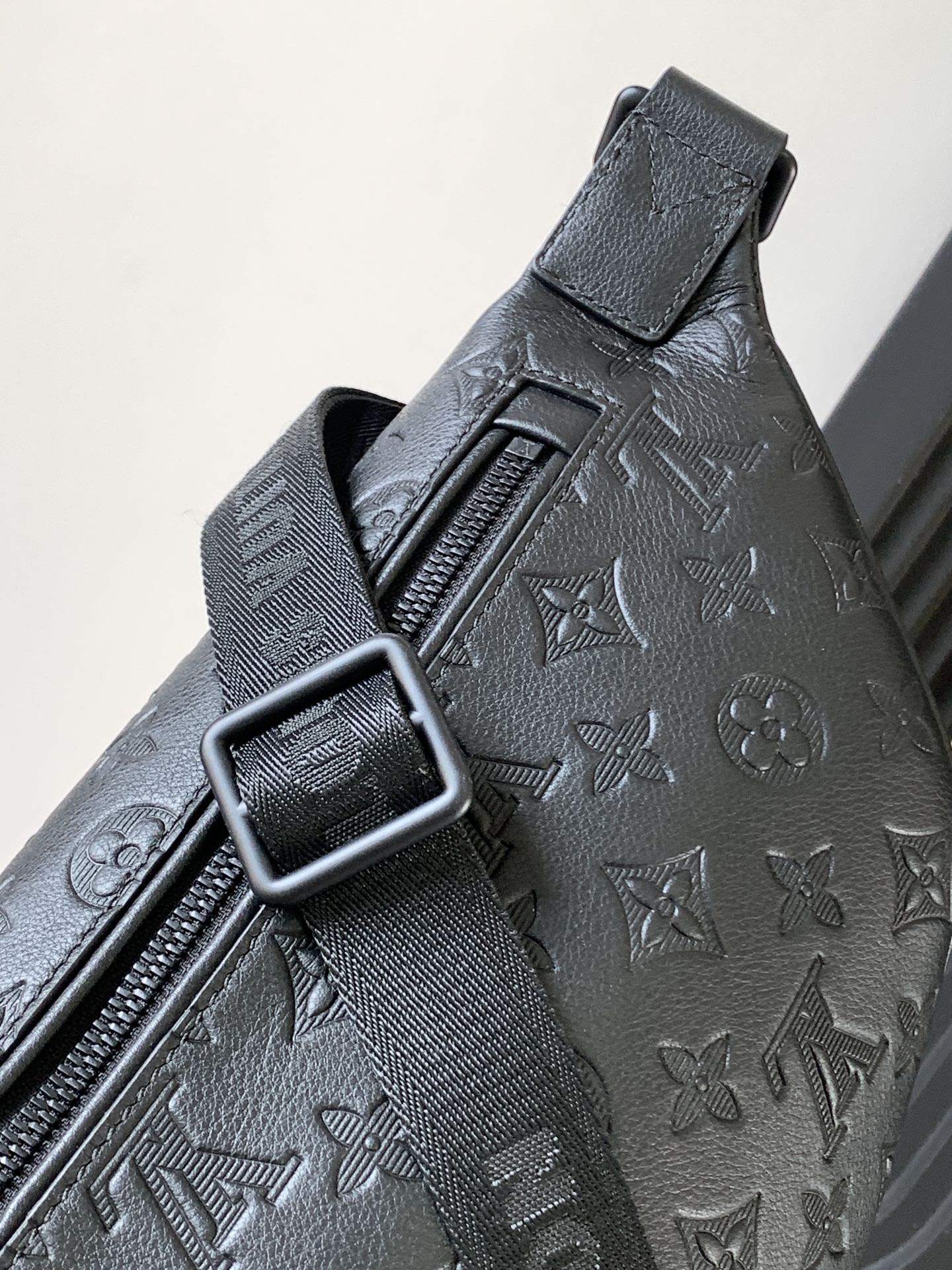 Louis Vuitton monogram crossbody bag close-up of strap buckle and embossed pattern