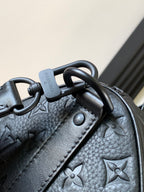 Dark monogram handbag corner with metal rings and textured leather detail